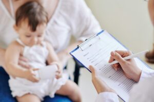 Pediatrician filling medical document