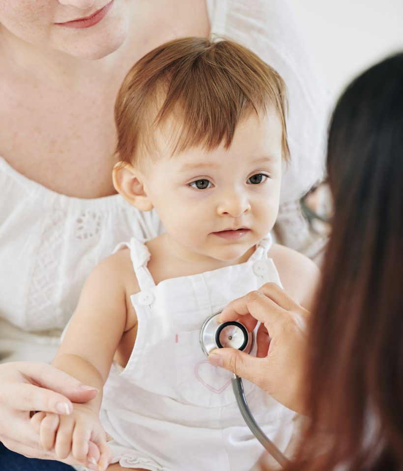 Pediatrician checking heartbeat